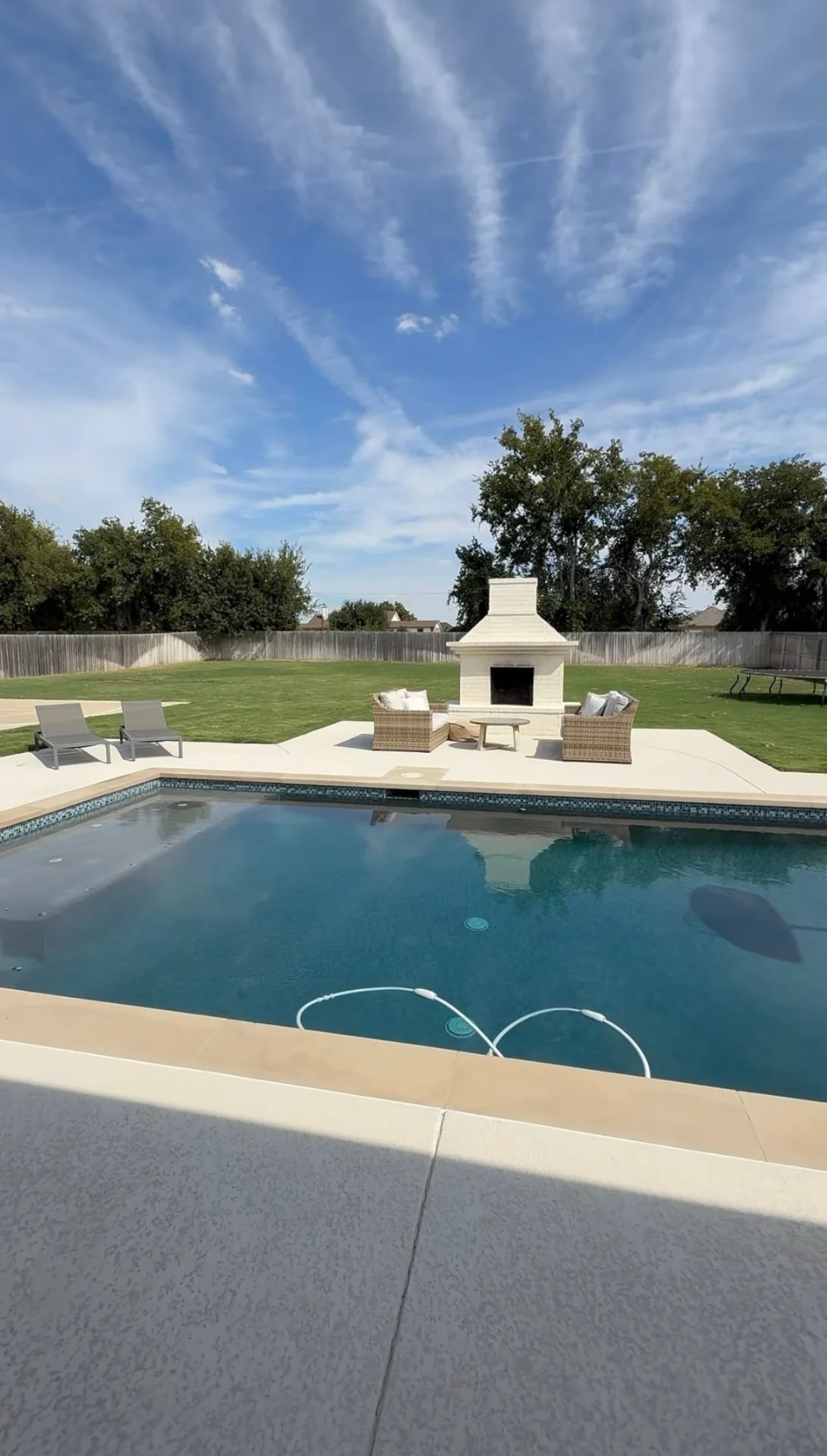 Backyard of a home in the Moffat area, with a swimming pool, patio fireplace and open lawn